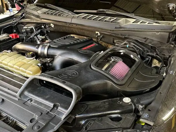 Car engine compartment with aftermarket air intake.
