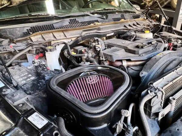 Open car hood showing engine components.