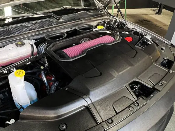 Car engine with hood open in garage.